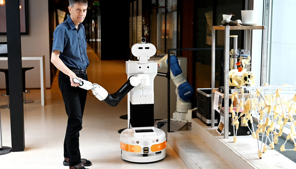 Robotforskeren Jim Tørresen ved UiO, her mens han hilsen på en robot. Et vaskeekte fotografi, men bildet er dog arrangert. Robotforskeren Jim Tørresen ved UiO, her mens han hilsen på en robot. Et vaskeekte fotografi, men bildet er dog arrangert.