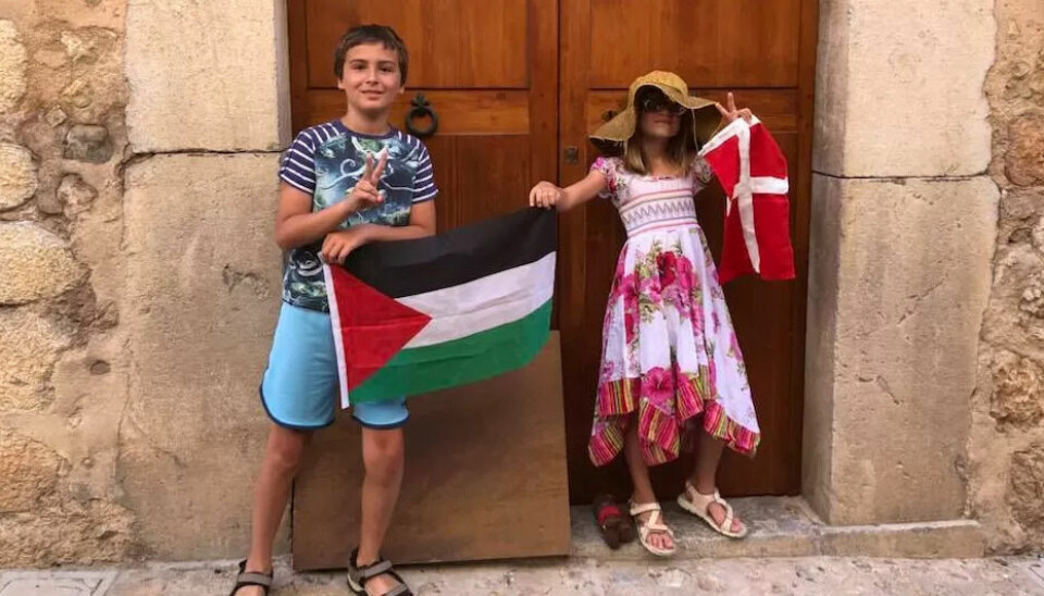 På ferie i Spania protesterte familien til Mikkel Grüner på behandlingen han og de andre fikk. Her holder sønn og datter Falk (11) og Bella (9) opp det palestinske og danske flagget. På ferie i Spania protesterte familien til Mikkel Grüner på behandlingen han og de andre fikk. Her holder sønn og datter Falk (11) og Bella (9) opp det palestinske og danske flagget.