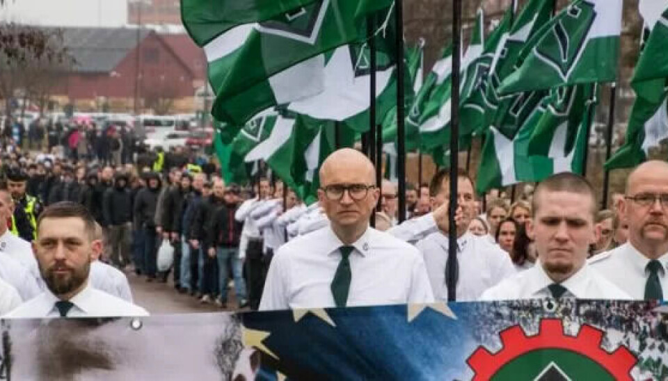 NAZITOG LUDVIKA 1. mai 2018: Her sees Anneli Virtanen i NMRs flaggborg og i nazistenes uniform for dagen (nummer tre fra høyre). Mannen foran til høyre med briller er Pär Öberg, en av NMRs mest markante profiler og ifølge ABC Nyheter den som hevder at Virtanen aldri har vært medlem. Foto: Nordfront NAZITOG LUDVIKA 1. mai 2018: Her sees Anneli Virtanen i NMRs flaggborg og i nazistenes uniform for dagen (nummer tre fra høyre). Mannen foran til høyre med briller er Pär Öberg, en av NMRs mest markante profiler og ifølge ABC Nyheter den som hevder at Virtanen aldri har vært medlem. Foto: Nordfront