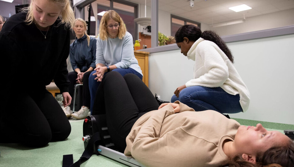 BÆRBAR HEIS: Ronja Ulfsrød (liggende), Chrystal Melissa Koko (t.h.) og Marie Langli Eriksen (t.v.) fra hjemmesykepleien i Fredrikstad trener på forflytningsteknikker i det nye simuleringssenteret ved Høgskolen i Østfold. Heidi Sægrov (bak) instruerer hvordan man skal bruke en bærbar heis. BÆRBAR HEIS: Ronja Ulfsrød (liggende), Chrystal Melissa Koko (t.h.) og Marie Langli Eriksen (t.v.) fra hjemmesykepleien i Fredrikstad trener på forflytningsteknikker i det nye simuleringssenteret ved Høgskolen i Østfold. Heidi Sægrov (bak) instruerer hvordan man skal bruke en bærbar heis.