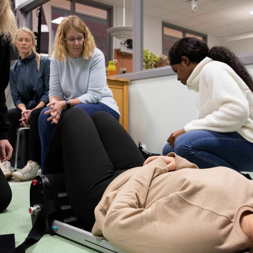 BÆRBAR HEIS: Ronja Ulfsrød (liggende), Chrystal Melissa Koko (t.h.) og Marie Langli Eriksen (t.v.) fra hjemmesykepleien i Fredrikstad trener på forflytningsteknikker i det nye simuleringssenteret ved Høgskolen i Østfold. Heidi Sægrov (bak) instruerer hvordan man skal bruke en bærbar heis. BÆRBAR HEIS: Ronja Ulfsrød (liggende), Chrystal Melissa Koko (t.h.) og Marie Langli Eriksen (t.v.) fra hjemmesykepleien i Fredrikstad trener på forflytningsteknikker i det nye simuleringssenteret ved Høgskolen i Østfold. Heidi Sægrov (bak) instruerer hvordan man skal bruke en bærbar heis.