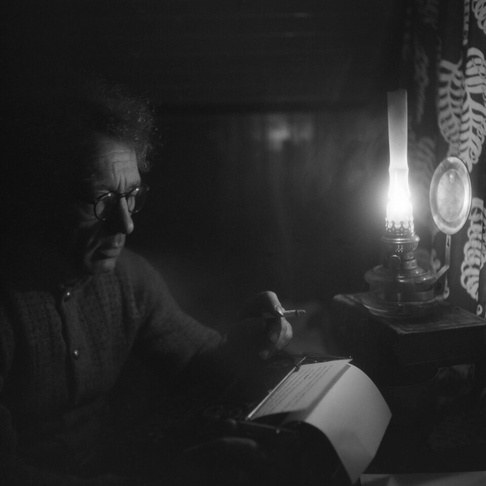 Her sitter Aksel Sandemose foran skrivemaskinen i lyset fra sin lampe hjemme på Kjørkelvik. Bildet er tatt i 1947. Her sitter Aksel Sandemose foran skrivemaskinen i lyset fra sin lampe hjemme på Kjørkelvik. Bildet er tatt i 1947.