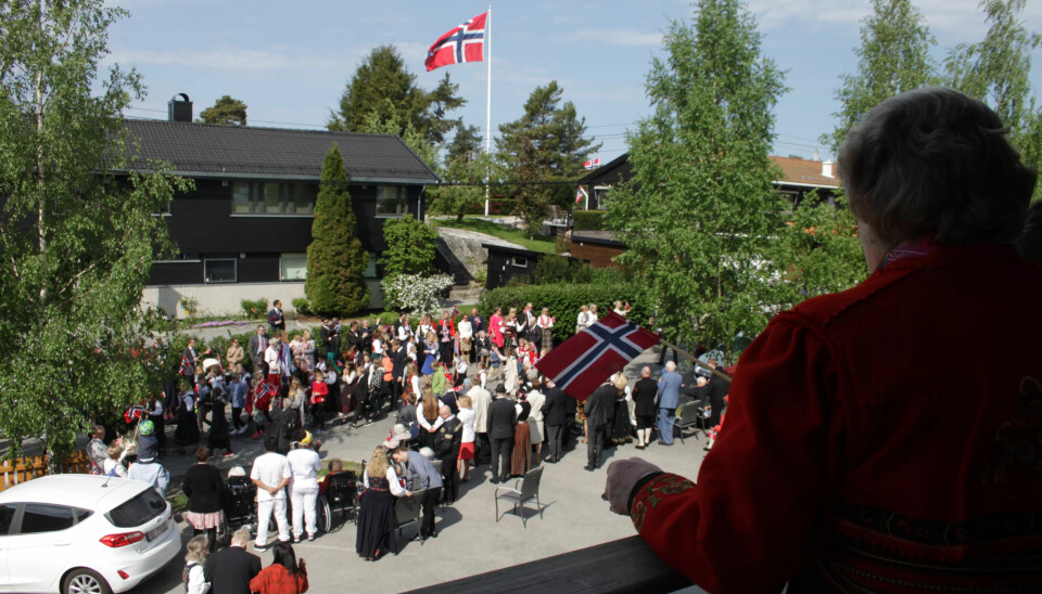 Toget spaserer forbi mens beboere vinker fra kongebalkongen. Toget spaserer forbi mens beboere vinker fra kongebalkongen.