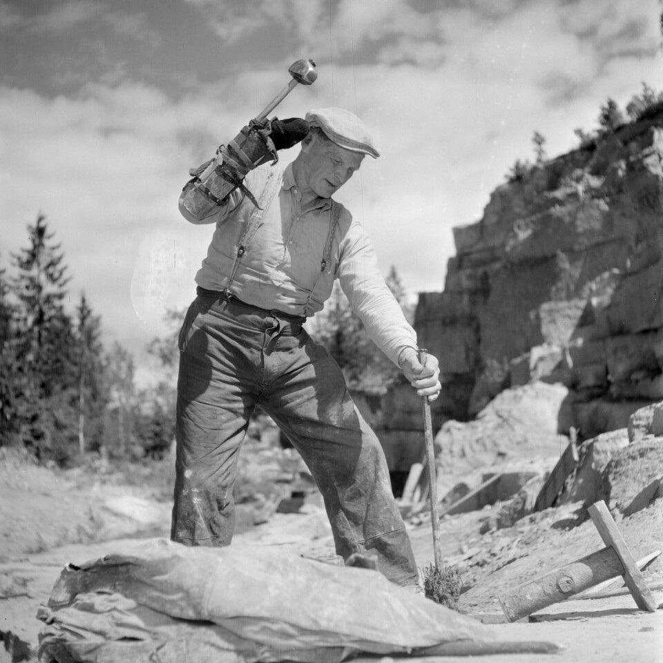 Steinhogger Sigfrid Westin i arbeid med slegge og spett. Steinhogger Sigfrid Westin i arbeid med slegge og spett.