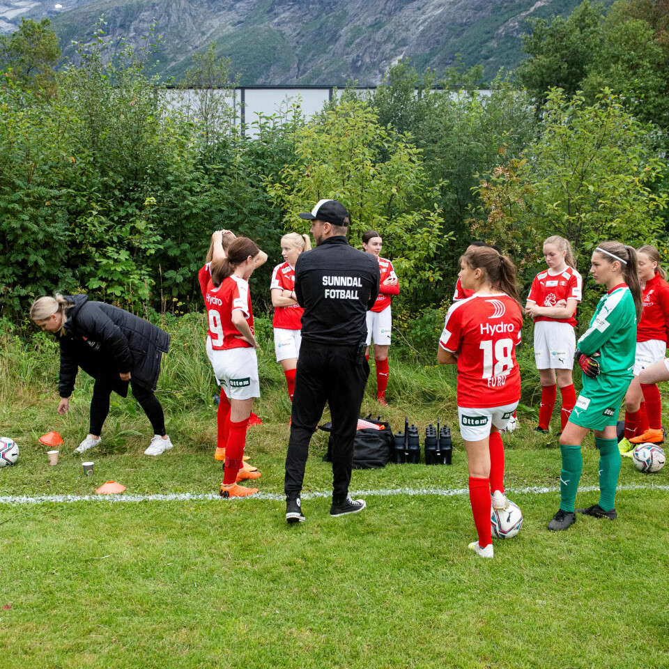 VINNERSJANSER: Motstanderlaget har brukt to timer på å kjøre fra det åpne havet i Hustadvika inn til Sunndals stupbratte fjell. Trener Espen Olsen og spillerne på Sunndal J15 gløtter mot dem for å vurdere motstanden. VINNERSJANSER: Motstanderlaget har brukt to timer på å kjøre fra det åpne havet i Hustadvika inn til Sunndals stupbratte fjell. Trener Espen Olsen og spillerne på Sunndal J15 gløtter mot dem for å vurdere motstanden.