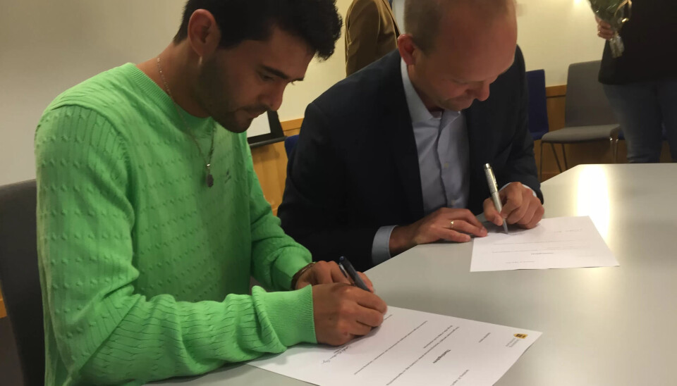 NAJIBOLLAH RAHINI: Signerer kontrakt med ordfører Sindre Martinsen Evje. NAJIBOLLAH RAHINI: Signerer kontrakt med ordfører Sindre Martinsen Evje.