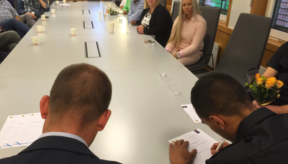 NY MEDARBEIDER: Taj Eddin Rahhaoui får hel og fast stilling i feiervesenet. Her signerer han kontrakten med ordfører Sindre Martinsen Evje. NY MEDARBEIDER: Taj Eddin Rahhaoui får hel og fast stilling i feiervesenet. Her signerer han kontrakten med ordfører Sindre Martinsen Evje.