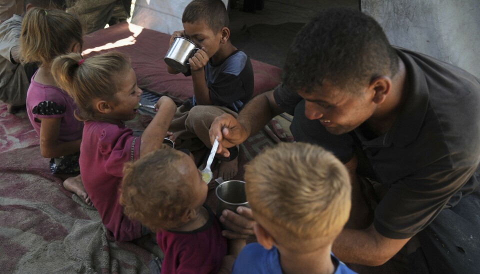 MAT: En palestinsk far gir linsesuppe til barna sine i en flyktningleir.